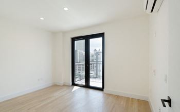 a living room with a sliding glass door to a balcony